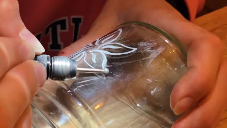 Closeup-of-a-girl-engraving-flower-on-a-glass-jar