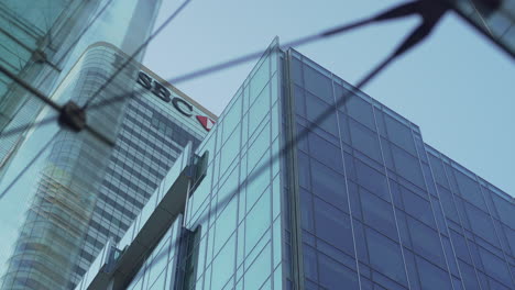 Low-angle-view-through-some-glasses-of-the-HSBC-building-in-Canary-Wharf,-London