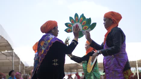 Slow-motion-view-of-women-in-colorful-satin-outfits-performing-a-dance-routine-during-an-outdoor-celebration