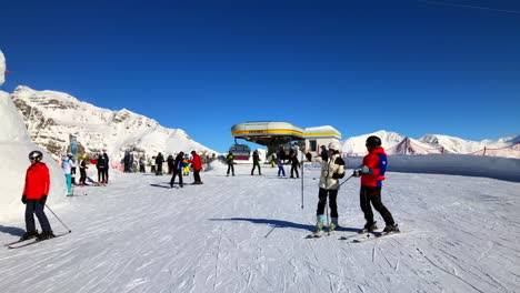 people-getting-out-of-a-ski-gondola-exit-on-the-mountain-top