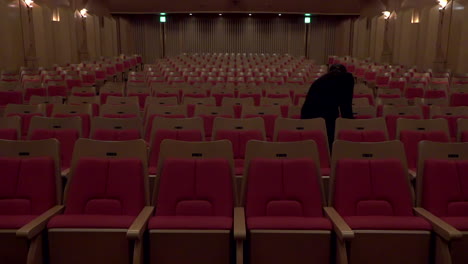 A-staff-walks-and-check-a-line-of-chairs-at-Oji-Hall,-Ginza,-Tokyo,-Japan,-2018