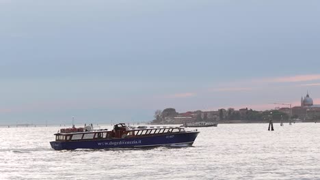 Motor-boat-passes-the-grand-canal-in-Venice,-Italy,-against-dramatic-sky