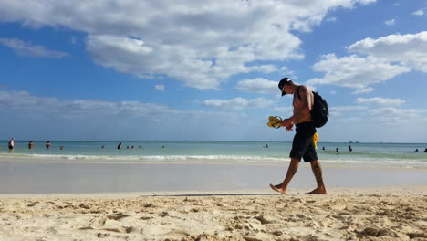 Mann-Mit-Tätowierungen-Und-Ohne-Hemd,-Der-Am-Strand-Vorbeigeht