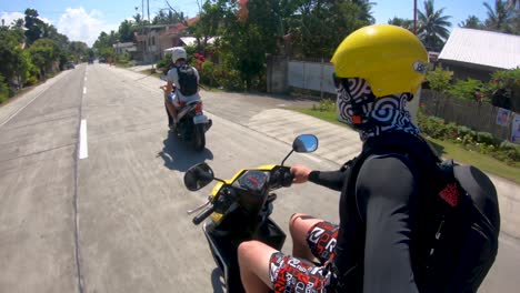 A-man-riding-a-motorcycle-on-a-dirt-road-on-the-island-of-Bohol,-Philippines