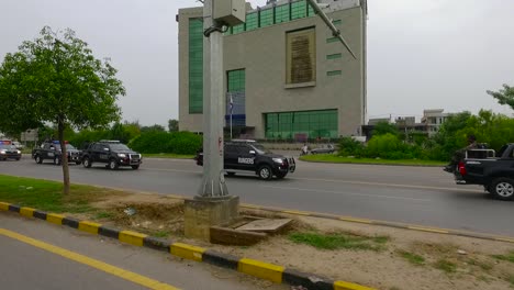 A-security-forces-convoy-is-on-patrolling-in-the-city,-Moving-on-the-road-with-other-traffic,-Aerial-view,-commandos-int-the-vans