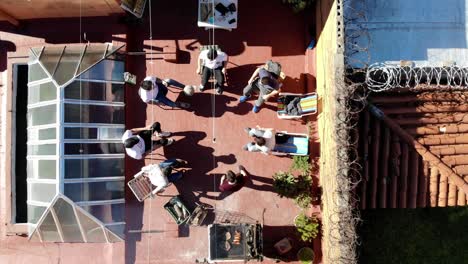 Aerial-view-of-rooftop-in-the-city-of-Montevideo-Uruguay-with-people-and-friends-having-a-barbecue-and-playing-football-on-a-sunny-day