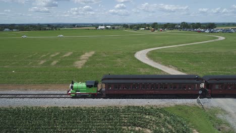 Vista-Aérea-De-Un-Percy-El-Motor-Del-Tanque-Con-Automóviles-De-Pasajeros-Resoplando-A-Lo-Largo-Del-Campo-Amish