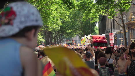 Niño-Pequeño-Que-Sostiene-Una-Bandera-Del-Orgullo-Gay-Está-Viendo-Pasar-La-Marcha-Por-él-En-París,-Francia