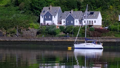 Runner-running-on-the-road-next-to-a-sailboat-on-the-river-in-the-early-morning