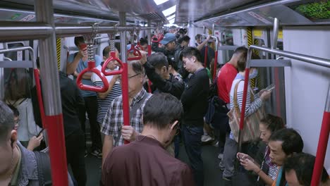 Viajeros-En-Un-Tren-De-Transporte-Público-Lleno-De-Gente-O-En-Un-Tren-Mrt-En-La-Red-De-Transporte-Subterráneo-De-Hong-Kong