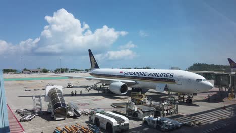 Vista-Del-Paisaje-Dentro-De-La-Terminal-Del-Aeropuerto-En-El-Aeropuerto-Internacional-De-Phuket-Con-El-Avión-Boeing777-200-Singapore-Airline-Plane-4k-Uhd-Video