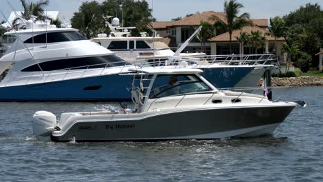 Fishing-boat-Big-Hammer-slowly-moving-down-the-waterway-with-large-yatch-in-background