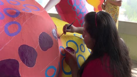 mexican-woman-painting-a-colourful-alebrije