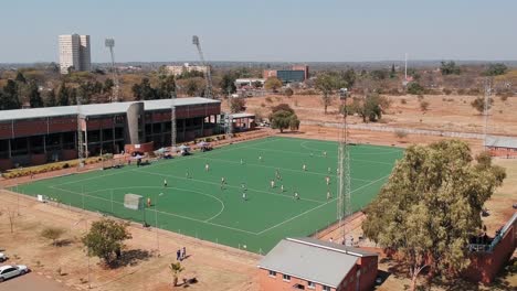 A-push-forward-drone-shot-of-a-field-hockey-game-under-sunny-conditions