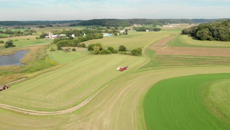 4k-Luftaufnahme-Eines-Mähdreschers,-Der-In-Der-Ferne-Heu-Erntet