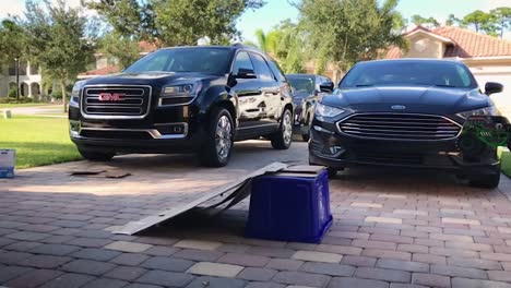 Elderly-adult-playing-with-his-grandsons-toys-in-the-driveway