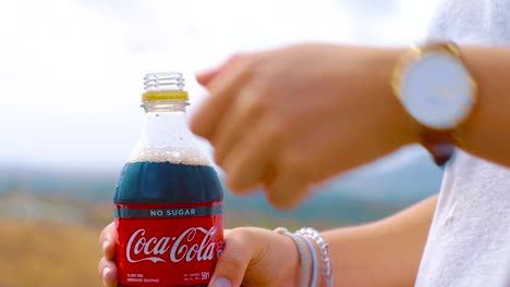 Opening-a-cold-bottle-of-coca-cola-zero-on-a-windy-day---Close-up