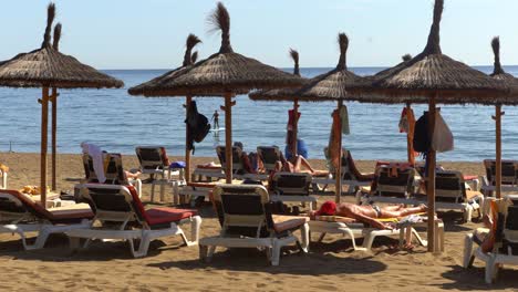 Pan-Rápido-De-4k-A-La-Izquierda-De-La-Playa-De-Marbella-En-Verano-Con-Turistas-Disfrutando-Del-Sol