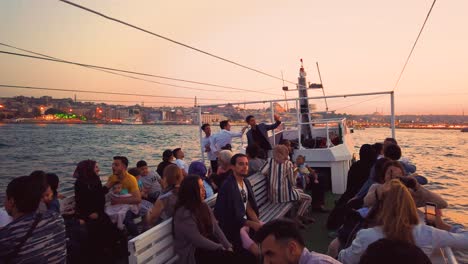 Cámara-Lenta:-Personas-No-Identificadas-Tienen-Un-Recorrido-En-Barco-Por-Estambul-Con-Vista-Al-Bósforo-Y-La-Nueva-Mezquita-Al-Atardecer-En-Estambul,-Turquía