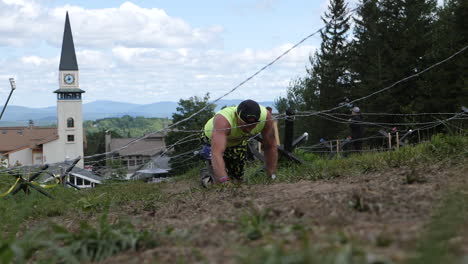 Obstacle-course-racing-athlete-crawling-through-barbwire-crawl-obstacle