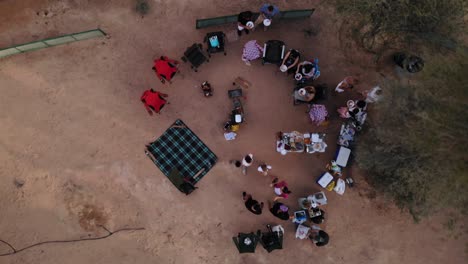 Vista-Aérea-Desde-Un-Dron-De-Amigos-Haciendo-Un-Picnic-Cerca-De-Los-Lagos-Al-Qudra-En-El-Desierto-De-Dubai,-Emiratos-árabes-Unidos