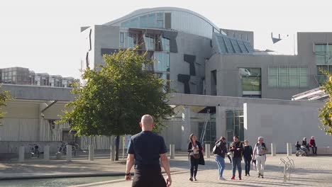 Slow-motion-of-tourist-outside-the-front-of-the-Scottish-Parliament-in-Edinburgh