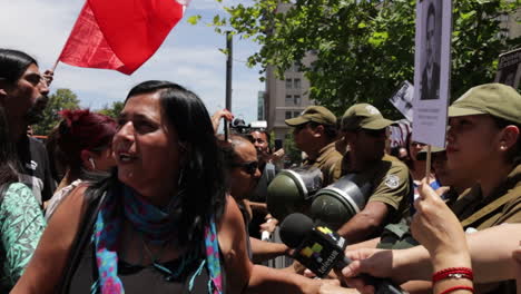 Protester-stand-at-a-barricade-of-military-enforcers-in-the-streets-of-Santiago