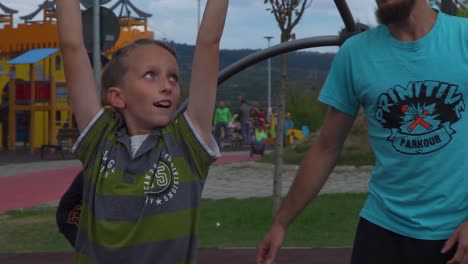 Un-Niño-Que-Muestra-Su-Determinación-De-Ser-Fuerte-Haciendo-Actividad-En-El-Entrenamiento-De-Parkour-En-Cluj-Rumania-Con-Su-Entrenador---Primer-Plano