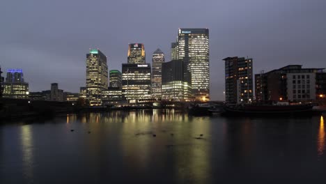 Zeitraffer-Des-Finanzviertels-Canary-Wharf-In-Der-Abenddämmerung-Mit-Enten-Im-Teich,-Docklands,-London,-Großbritannien