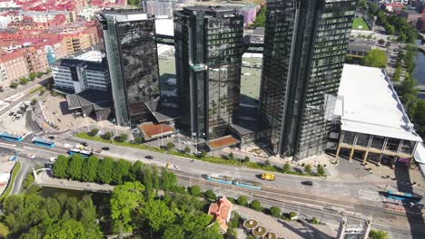 Drone-shot-at-glass-fronted-with-reflections-buildings-next-to-Liseberg-amusement,-Göteborg