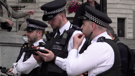 Ein-Polizist-Benutzt-Ein-Computer-Tablet-Während-Einer-Kontrolle-Und-Durchsuchung-Von-Umweltaktivisten,-Die-An-Einer-Protestaktion-Der-Beyond-Politics-Partei-Auf-Dem-Trafalgar-Square-Teilnehmen