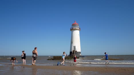 Familia-De-Turistas-Jugando-En-El-Emblemático-Faro-De-Ayr-Abandonado-Playa-De-Arena-Costa