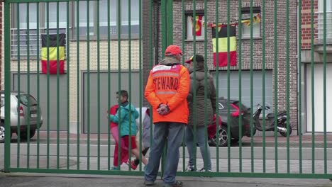 Älterer-Mann-Bewacht-Das-Tor-Als-Steward-In-Orangefarbener-Jacke-Und-Mit-Orangefarbener-Mütze-Im-Stadion,-Bevor-Das-Fußballspiel-Beginnt