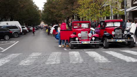 Touristen-Umrunden-Die-Roten-Historischen-Autos-In-Prag,-Tschechien,-Bevor-Sie-Eine-Fahrt-Unternehmen