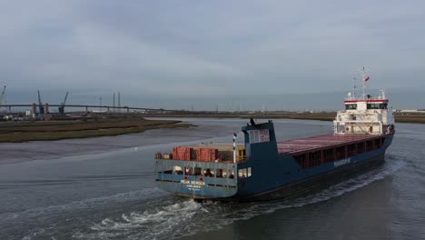 Aerial-tracking-shot-close-to-the-Peak-Bergen-ship-sailing-along-the-Swale-Estuary-towards-the-Sheppey-Crossing-in-Kent,-UK