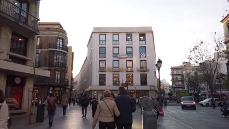 Gente-Caminando-Por-Las-Concurridas-Calles-De-La-Zona-Comercial-De-Sevilla,-Cámara-Lenta-Inclinada-Hacia-Arriba