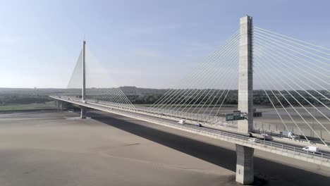 Vehicles-crossing-contemporary-Mersey-Gateway-bridge-aerial-view-at-low-tide