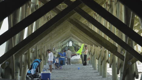 People-Relaxing-Underneath-Folly-Beach-Pier-on-Sunny-Beach-Day