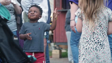 Little-boy-jumping-with-excitement-and-joy-in-crowd,-Slow-Motion