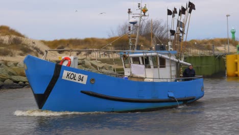 Blue-Fishing-Boat-sails-into-port-in-Kolobrzeg,-Poland