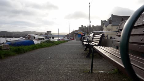 Leere-Hafenholzbänke-Am-Conwy-Waterfront-Marina-Während-Der-Covid-Sperre,-Dolly-Im-Niedrigen-Winkel-Nach-Links