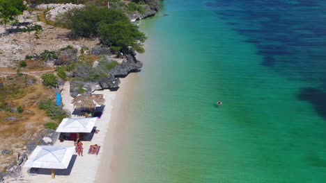 Reverse-aerial-pullout-looking-down-on-people-enjoying-beach-in-Philippines