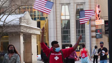 Junger-Afroamerikanischer-Mann-Schwenkt-Amerikanische-Flagge-Und-Feiert-Bidens-Wahlsieg-In-Columbus,-Ohio