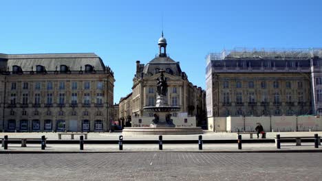 Plaza-De-La-Place-De-La-Bourse-Con-Autos-Que-Pasan-Frente-A-Una-Plaza-Vacía-Debido-A-La-Pandemia-De-Covid-19,-Toma-De-Mano-Estable