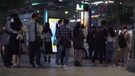 Coreanos-Con-Máscaras-Protectoras-Esperando-En-Fila-Para-Tomar-El-Autobús-En-La-Parada-De-Autobús-Del-Distrito-De-Gangnam-Por-La-Noche