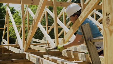 Trabajadora-De-La-Construcción-Golpeando-El-Clavo-Alrededor-Del-Marco,-Medio