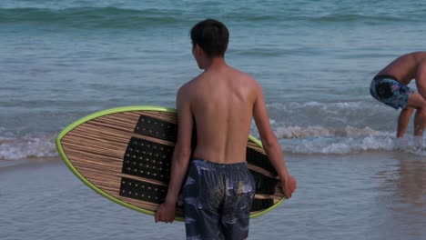 Se-Ve-A-Un-Hombre-Con-Su-Tabla-De-Surf-En-La-Playa-De-Shek-O-En-Hong-Kong-Mientras-Las-Playas-Públicas-Reabren-Al-Público,-Después-De-Meses-De-Cierre-En-Medio-Del-Brote-De-Coronavirus