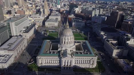 City-Hall-Aerial-fly-up-and-look-down-shot-located-in-the-city's-civic-center-district-at-evening-with-people-ice-skating-on-rink