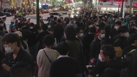 Multitud-Con-Máscaras-Faciales-Caminando-Y-De-Pie-A-Lo-Largo-De-Las-Aceras-En-El-Cruce-De-Shibuya-En-La-Noche-De-Halloween-2020---Plano-Medio