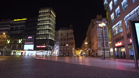 La-Parte-Inferior-De-La-Plaza-Wenceslao-En-Praga,-Chequia-Por-La-Noche,-Centros-Comerciales-Iluminados-Con-Luces-De-Neón,-Toda-El-área-Vacía-Sin-Gente-Debido-A-Un-Cierre-De-Covid-19,-Calles-Iluminadas-Con-Luces,-Tiro-Panorámico